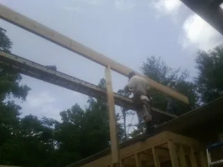 Carpenter setting a ridge beam over a new addition frame — Ice Dam Removal by Roofing Brothers in Salmon