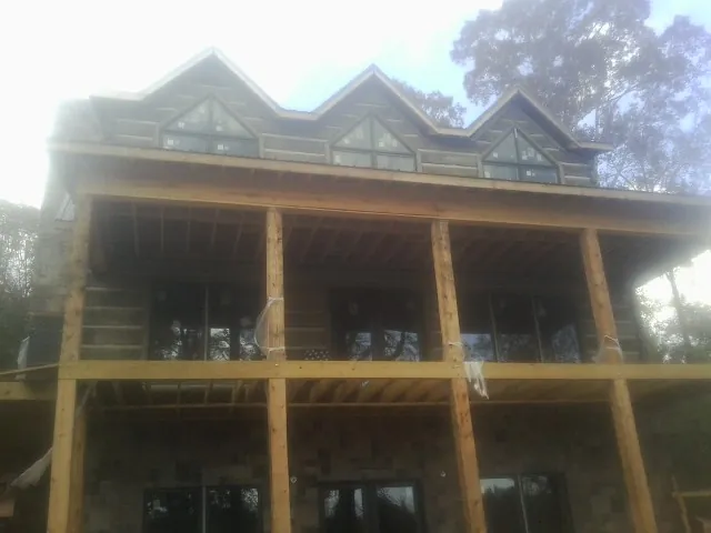Dormers and porch framing on a large log home under construction — Roof Coating work by our crew in Salmon