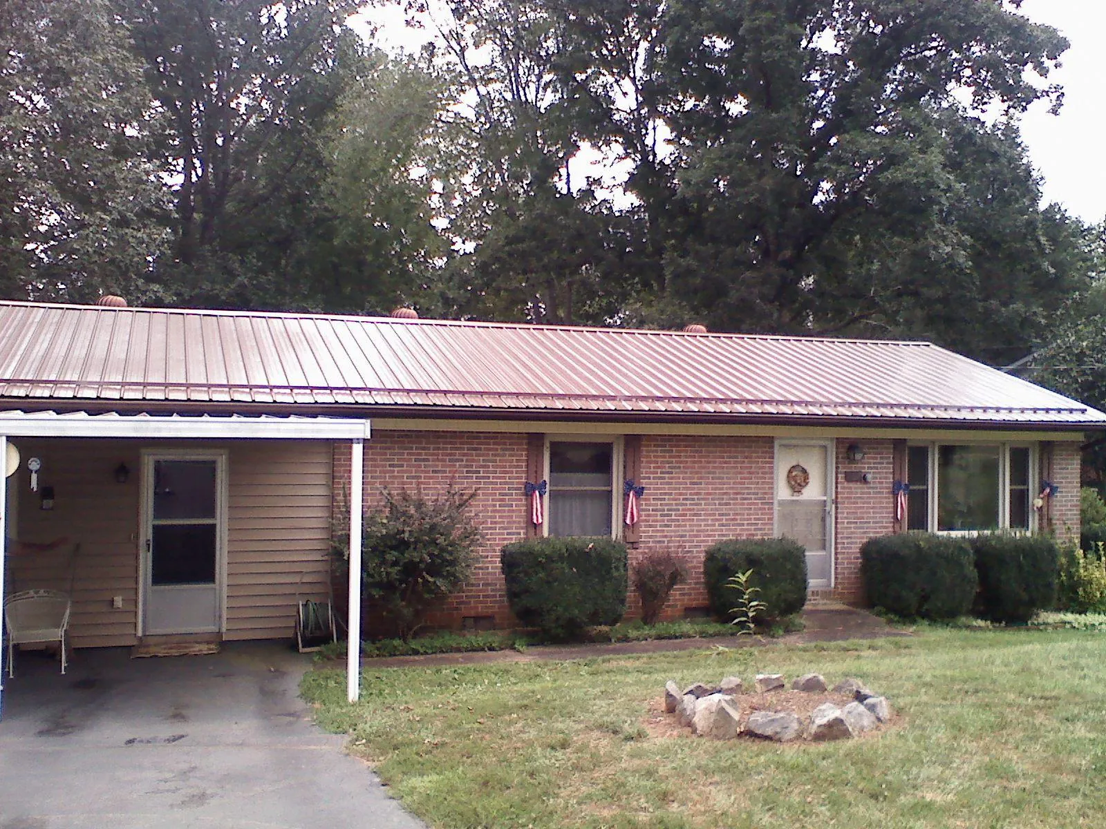 Bronze metal roof and carport on a brick ranch home — Roof Repair work by our crew in Salmon